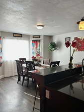 Dining space with hardwood / wood-style floors and a textured ceiling