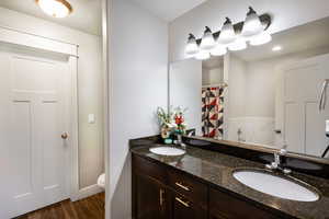 Bathroom featuring hardwood / wood-style floors, vanity, and toilet