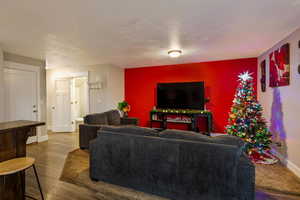 Living room with hardwood / wood-style floors and a textured ceiling