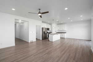 Unfurnished living room with ceiling fan, dark hardwood / wood-style flooring, and sink