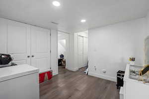 Laundry area featuring dark wood-type flooring