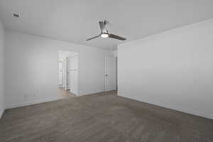 Carpeted spare room featuring ceiling fan