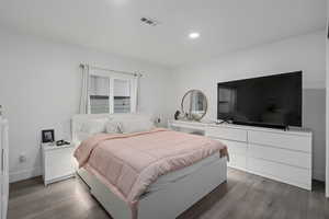 Bedroom with dark hardwood / wood-style flooring