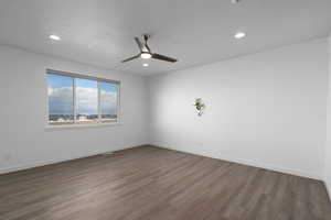 Unfurnished room with a textured ceiling, hardwood / wood-style flooring, and ceiling fan