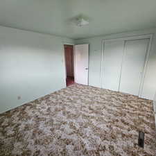 Unfurnished bedroom featuring carpet floors and a closet