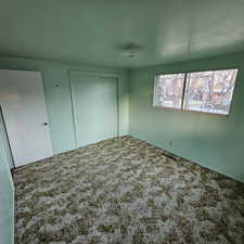 Unfurnished bedroom featuring a closet and carpet floors