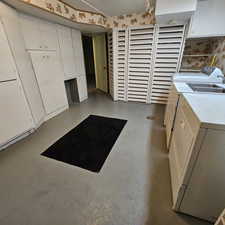 Washroom featuring washer and clothes dryer and cabinets