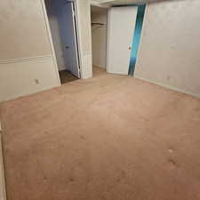 Unfurnished bedroom featuring light carpet and a closet