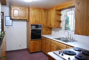 Kitchen with black oven, stainless steel range, and sink