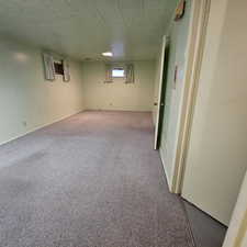 Basement featuring a textured ceiling and carpet floors