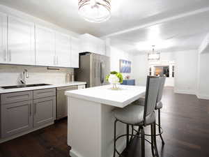 Kitchen featuring gray cabinetry, sink, tasteful backsplash, dark hardwood / wood-style flooring, and appliances with stainless steel finishes