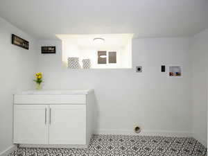 Washroom featuring hookup for an electric dryer, cabinets, and hookup for a washing machine