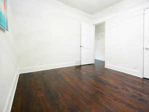 Spare room with dark hardwood / wood-style flooring