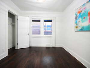 Unfurnished bedroom with a closet and dark wood-type flooring