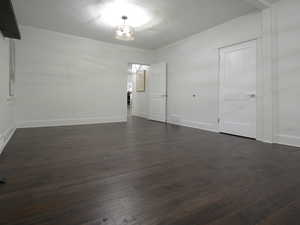 Spare room featuring dark hardwood / wood-style flooring and a textured ceiling