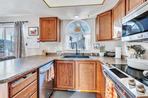 Kitchen featuring kitchen peninsula, appliances with stainless steel finishes, and sink