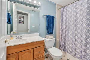 Bathroom with vanity, a textured ceiling, and toilet