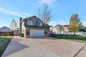 Front of property with a garage and a front yard