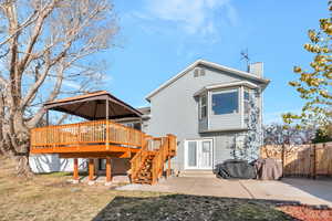 Back of house featuring a lawn, french doors, a patio, and a deck