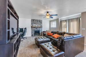 Living room featuring a textured ceiling, carpet floors, ceiling fan, and wooden walls