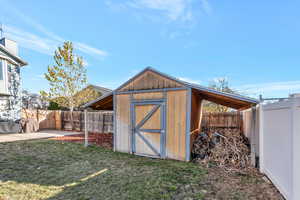 View of outdoor structure featuring a lawn