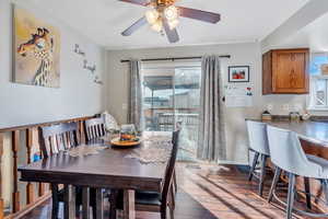 Dining space with dark hardwood / wood-style flooring and ceiling fan