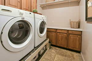 Laundry room featuring washing machine and dryer and cabinets