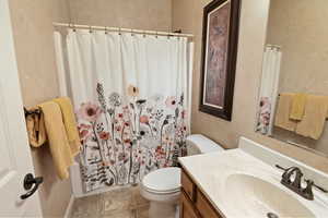 Full bathroom with tile patterned flooring, shower / tub combo, vanity, and toilet