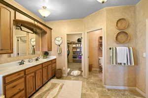 Bathroom featuring vanity, a textured ceiling, and toilet