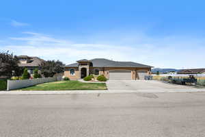 View of front facade featuring a mountain view, a front lawn, and a garage