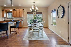 Dining area with a chandelier and dark hardwood / wood-style floors