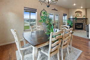 Dining room with a stone fireplace, plenty of natural light, and hardwood / wood-style floors