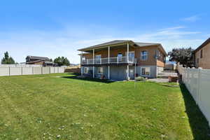 Rear view of house featuring a lawn