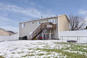 Snow covered rear of property featuring a deck and central air condition unit