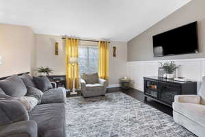 Living room featuring dark wood-type flooring and vaulted ceiling