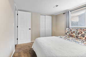 Bedroom featuring carpet and a closet