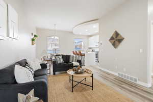 Living room with light hardwood / wood-style flooring and a chandelier