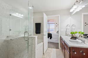 Bathroom featuring plus walk in shower, vanity, and tile patterned floors