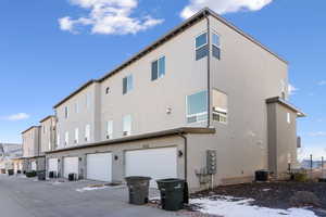 Rear view of property featuring cooling unit and a garage