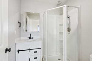 Bathroom with vanity, toilet, and an enclosed shower