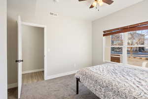 Carpeted bedroom featuring ceiling fan