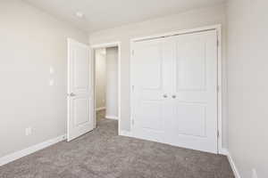 Unfurnished bedroom with a closet and light colored carpet