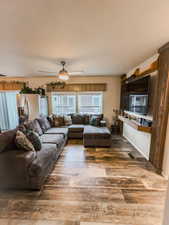 Living room featuring wood-type flooring and ceiling fan