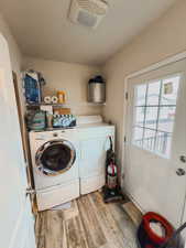 Washroom with separate washer and dryer and hardwood / wood-style flooring