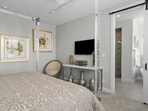 Carpeted Ensuite Master bedroom featuring a barn door