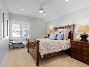 Bedroom featuring ceiling fan, light colored carpet, and vaulted ceiling