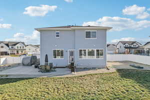 Back of property featuring a lawn and a patio