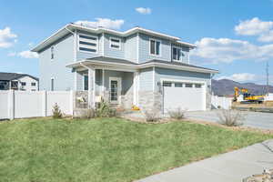 View of front of home with a mountain view, a garage, and a front yard