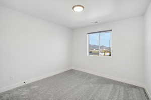 Spare room with carpet flooring and a mountain view