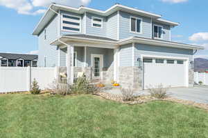 View of front of house with a garage and a front lawn